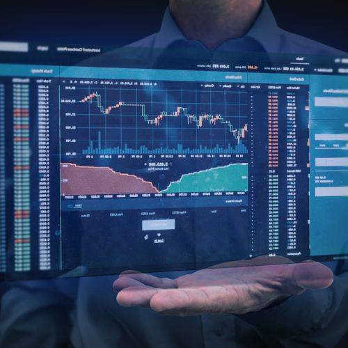 Kanak Capital Markets digital trading dashboard with interactive charts, held above a business professional’s hand.